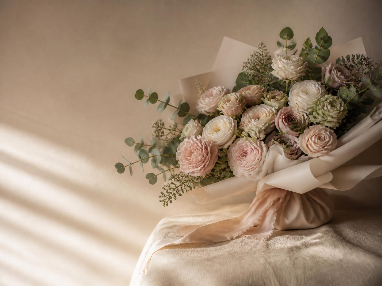 Blush and cream garden rose bouquet wrapped in ivory paper by Florería Nava in Arlington, TX